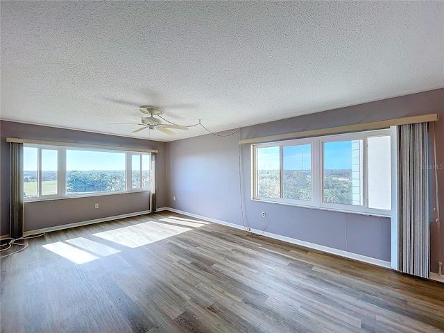 unfurnished room featuring ceiling fan, wood-type flooring, and a textured ceiling