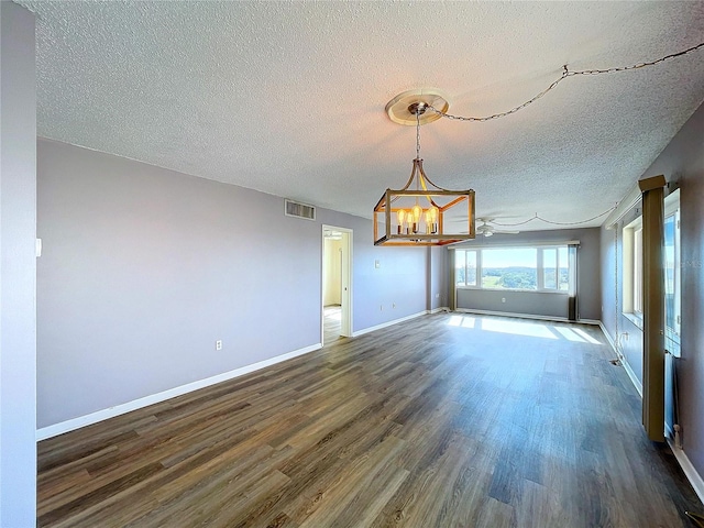 interior space featuring a notable chandelier, a textured ceiling, and dark wood-type flooring