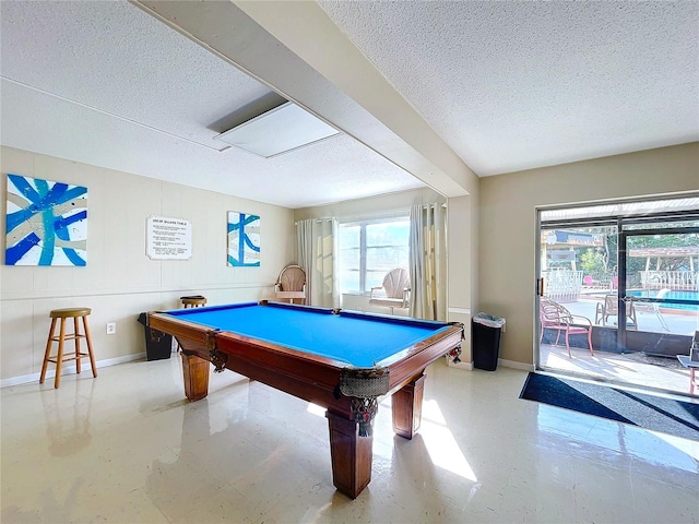 recreation room with beam ceiling, a healthy amount of sunlight, a textured ceiling, and billiards