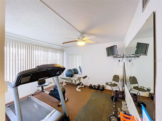 exercise room with ceiling fan and a textured ceiling