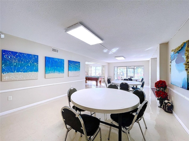 dining room with a textured ceiling and pool table