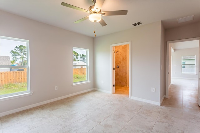 tiled empty room featuring ceiling fan