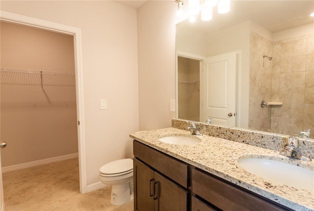 447 Reading St, Lehigh Acres, FL 33974 - full bath featuring double vanity, toilet, a walk in closet, a tile shower, and tile patterned flooring
