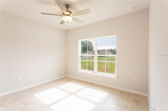 tiled spare room with ceiling fan