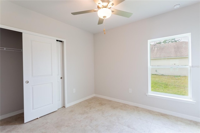 unfurnished bedroom with light tile patterned floors, a closet, and ceiling fan