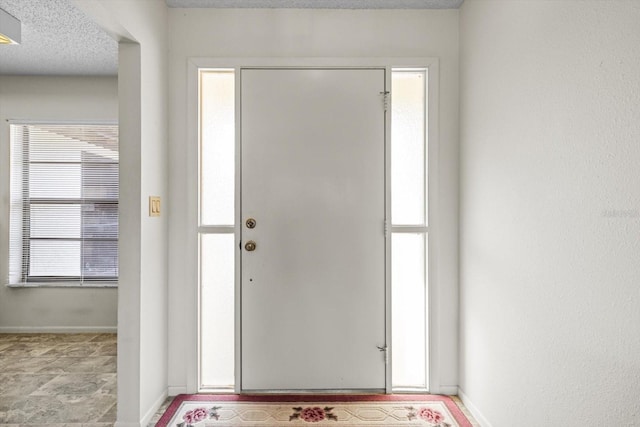 foyer entrance with a textured ceiling