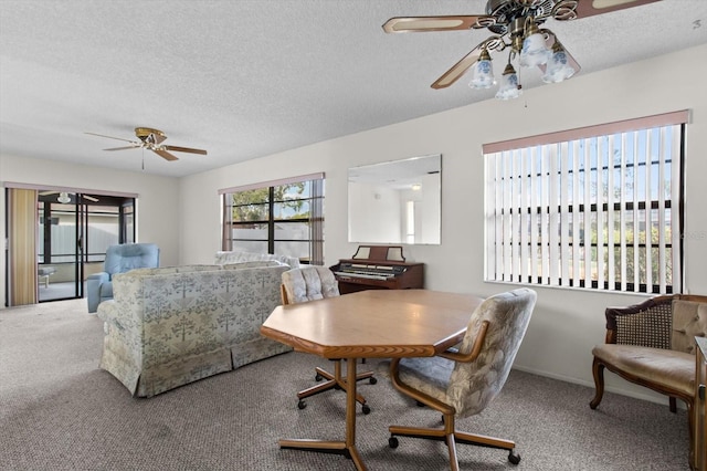 carpeted dining space with ceiling fan and a textured ceiling