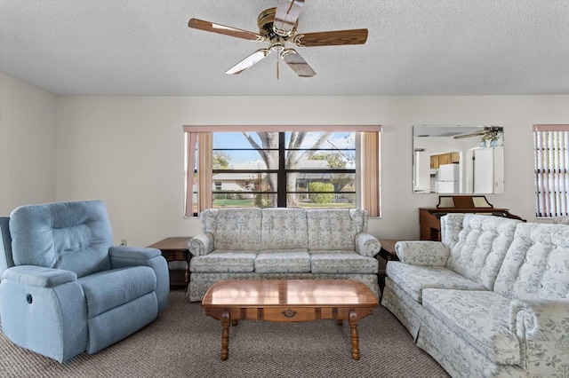 carpeted living room with ceiling fan and a textured ceiling