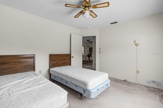 carpeted bedroom featuring a textured ceiling and ceiling fan