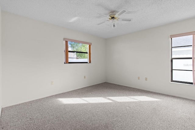 spare room featuring carpet flooring, ceiling fan, a healthy amount of sunlight, and a textured ceiling