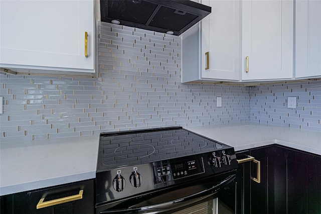 kitchen featuring black range with electric stovetop, white cabinets, light countertops, ventilation hood, and decorative backsplash