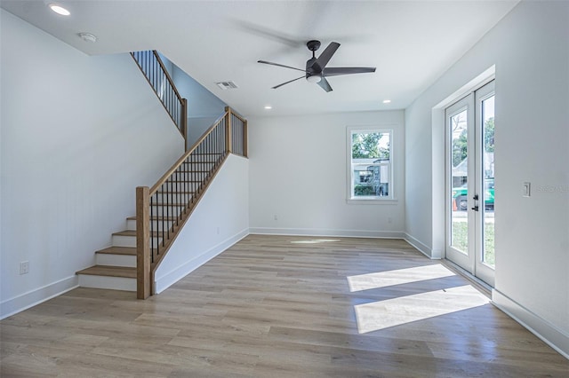 unfurnished living room featuring french doors, visible vents, stairway, wood finished floors, and baseboards