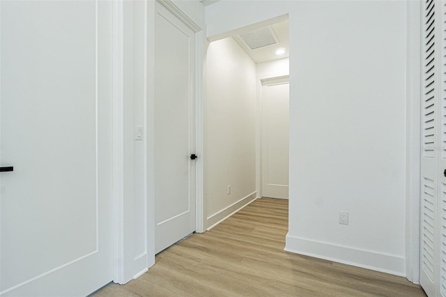 corridor featuring baseboards and light wood-style floors