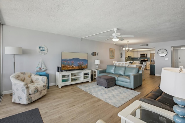 living room with ceiling fan, wood-type flooring, and a textured ceiling