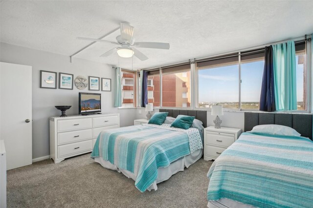 carpeted bedroom with ceiling fan and a textured ceiling