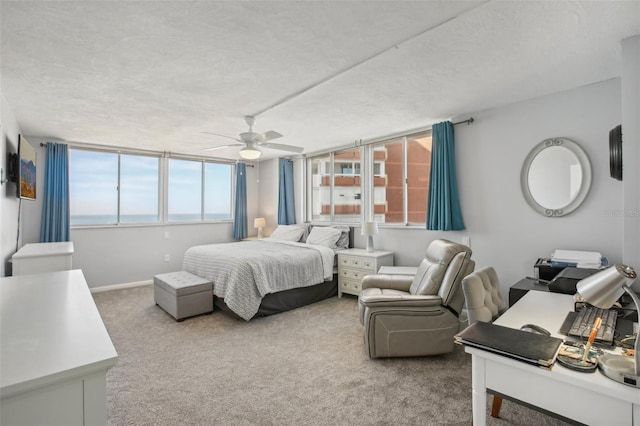 carpeted bedroom featuring multiple windows, a textured ceiling, and ceiling fan