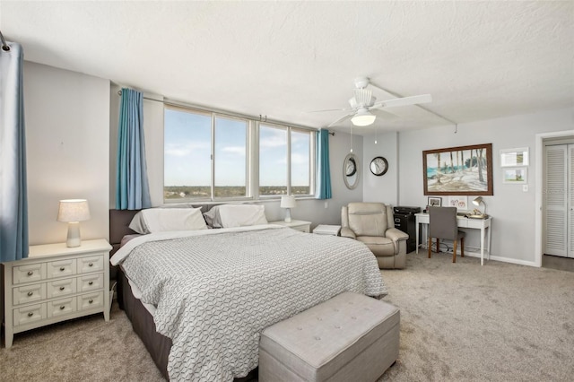 carpeted bedroom featuring ceiling fan and a textured ceiling