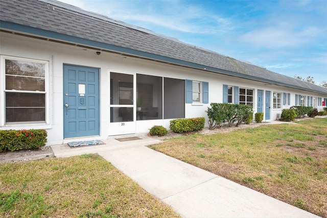 view of exterior entry with a lawn