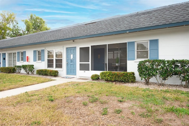 rear view of property with a sunroom and a yard