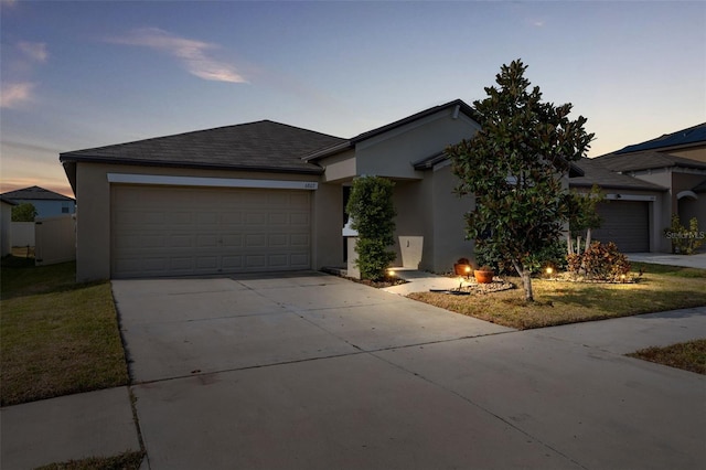 ranch-style home with a lawn and a garage