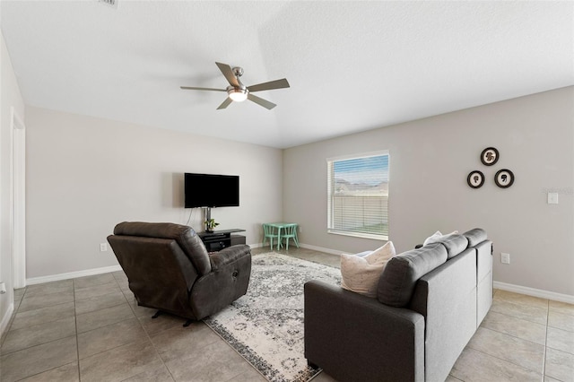 living room featuring ceiling fan, light tile patterned floors, and a textured ceiling