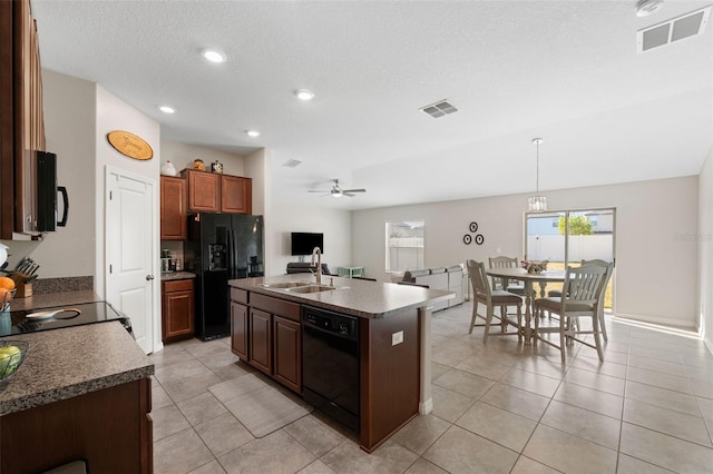 kitchen with ceiling fan, sink, black appliances, a center island with sink, and hanging light fixtures