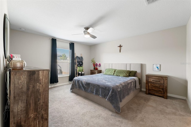 carpeted bedroom featuring a textured ceiling and ceiling fan