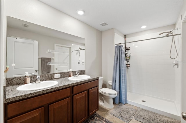 bathroom with tile patterned floors, vanity, toilet, and curtained shower