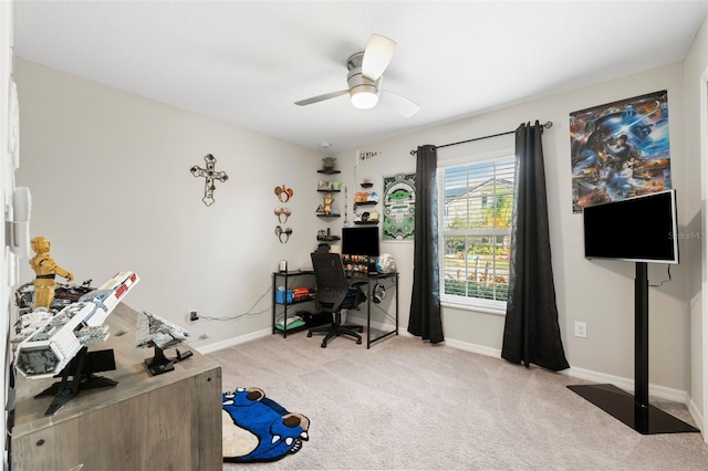 carpeted home office featuring ceiling fan