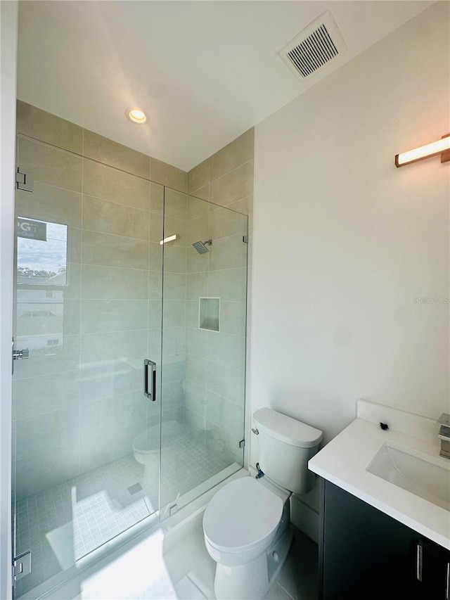 bathroom with tile patterned floors, walk in shower, vanity, and toilet