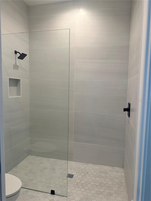 bathroom featuring toilet and tiled shower