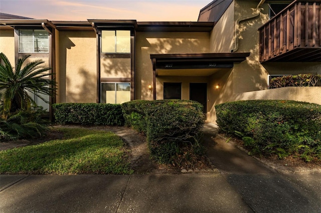 exterior entry at dusk featuring a balcony