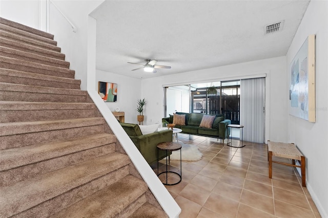 tiled living room featuring a textured ceiling and ceiling fan