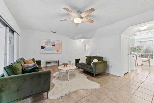 tiled living room featuring ceiling fan and a textured ceiling