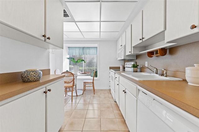 kitchen with white cabinets, white appliances, light tile patterned flooring, and sink