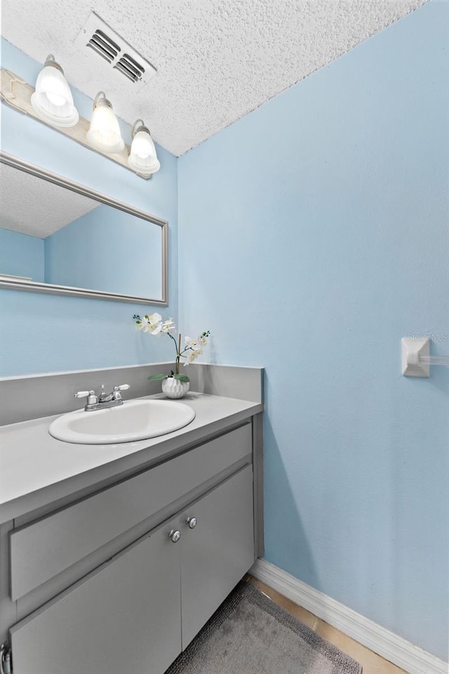 bathroom featuring a textured ceiling and vanity