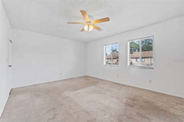 carpeted empty room with ceiling fan and a textured ceiling