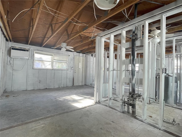 basement featuring ceiling fan, water heater, and a wall mounted air conditioner