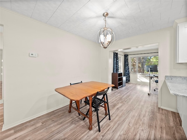 dining room featuring light wood-type flooring, crown molding, and a chandelier