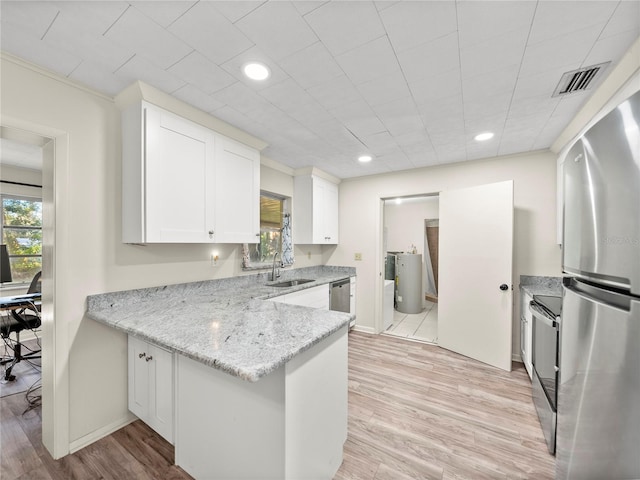 kitchen with white cabinetry, sink, appliances with stainless steel finishes, and light hardwood / wood-style flooring