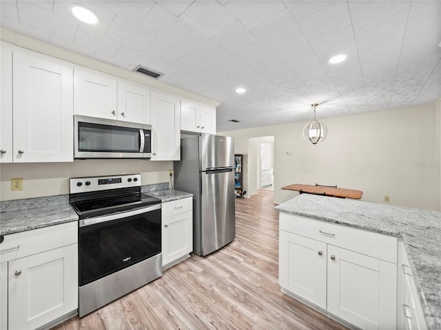 kitchen featuring white cabinetry, light stone counters, light hardwood / wood-style flooring, pendant lighting, and appliances with stainless steel finishes