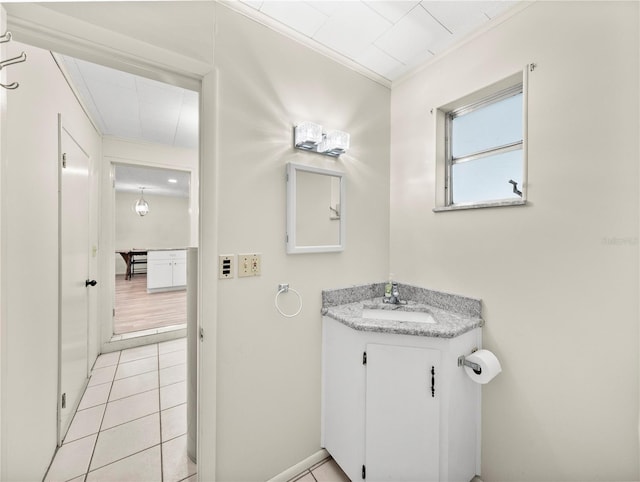 bathroom featuring tile patterned flooring, vanity, and ornamental molding