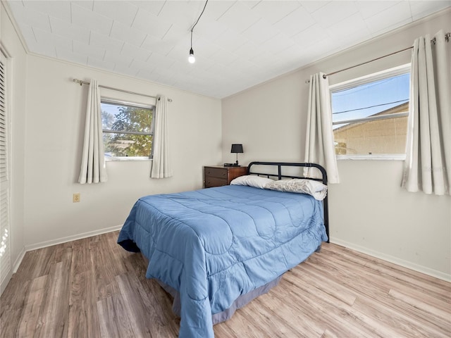 bedroom featuring multiple windows, crown molding, and hardwood / wood-style floors