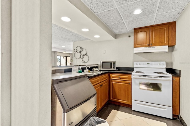 kitchen featuring sink, a drop ceiling, dark tile patterned flooring, and white electric stove