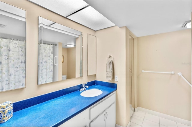 bathroom with tile patterned flooring, vanity, and toilet