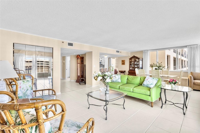 living room with light tile patterned flooring and a textured ceiling