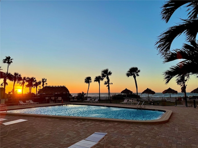 pool at dusk with a patio area