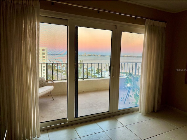 entryway featuring a water view and light tile patterned flooring