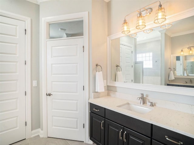 bathroom featuring a chandelier, vanity, tile patterned flooring, and crown molding