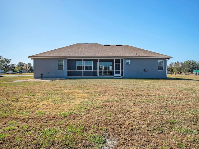 rear view of house featuring a sunroom and a yard